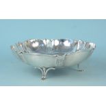 A large white metal shaped bowl on three legs with pierced panel decoration,
