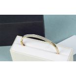 A 9ct gold diamond set bangle,