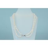 A pearl necklace with white metal clasp stamped 14k