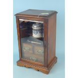 An early 20th Century oak smokers cabinet with thee drawers,
