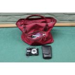 An Olympus X-44 digital camera with a bag of accessories