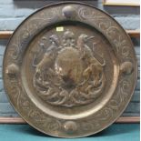 A substantial pressed brass wall charger depicting lions flanking shield and crown,