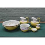 A double dressing room wash set, yellow with flowers, two bowls (one with hairline), two jugs,