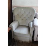 A high back wing armchair with button back beige upholstery