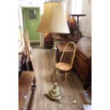 An early 20th Century brass standard lamp on a round fluted base with shaped feet