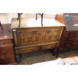 A Jacobean style cupboard, the carved front with lift up lid,