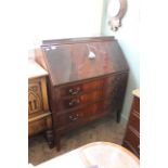 A 1930's three drawer mahogany bureau with fitted interior