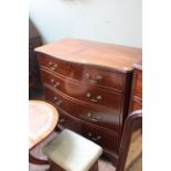 A Georgian style mahogany serpentine chest of four drawers