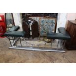 A Victorian style club fender in polished steel with green leather end seats
