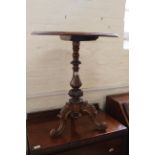 A Victorian walnut tripod table on carved tripod legs