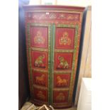 An Indian bow fronted two door cupboard with hand painted decoration of flowers,