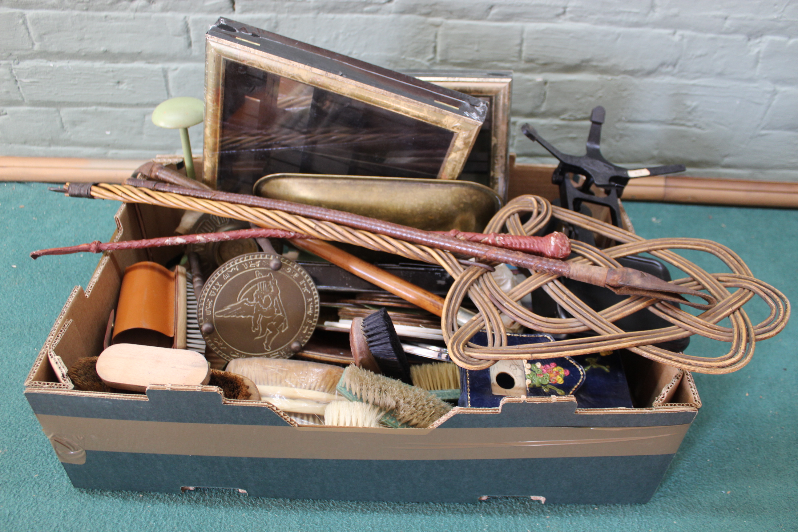 A mixed box of items including a set of scales, small display boxes, riding crops,