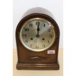 An oak cased chiming mantel clock with silvered dial and key