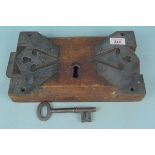 A large antique wooden and metal lock with key, 30cm x 18.