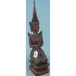 An eastern carved wooden figurine of a deity,