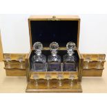 An oak cased three bottle Tantalus with eight small glasses,