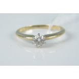 An unmarked yellow metal solitaire diamond set ring, size N,