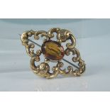 An unmarked yellow metal antique citrine set brooch with engraved decoration