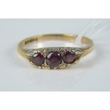 A 9ct gold three stone garnet set ring, size O, weight approx 2.