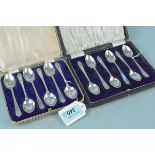 Two sets of six silver teaspoons, both cased and one with golf decoration,