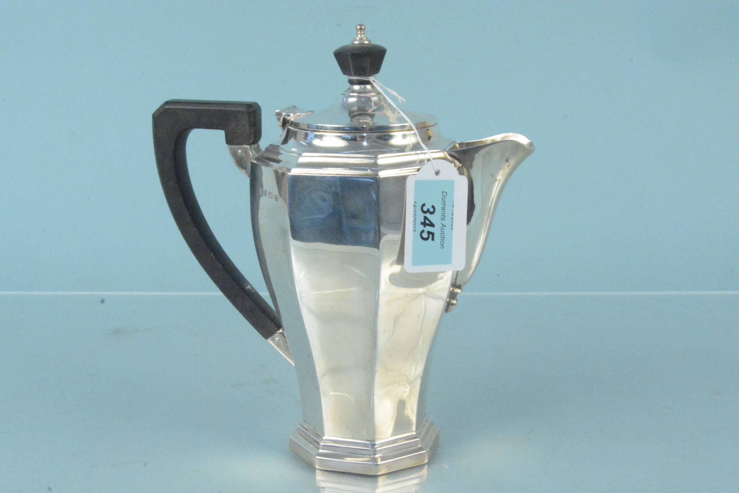 A silver water jug of octagonal design with wooden handle and finial, hallmarked Birmingham 1931,