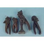 Four vintage continental wooden nut crackers with handles, carved as caricature faces,