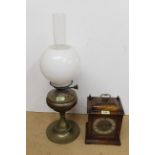 A mantel clock with brass details plus an oil lamp with shades