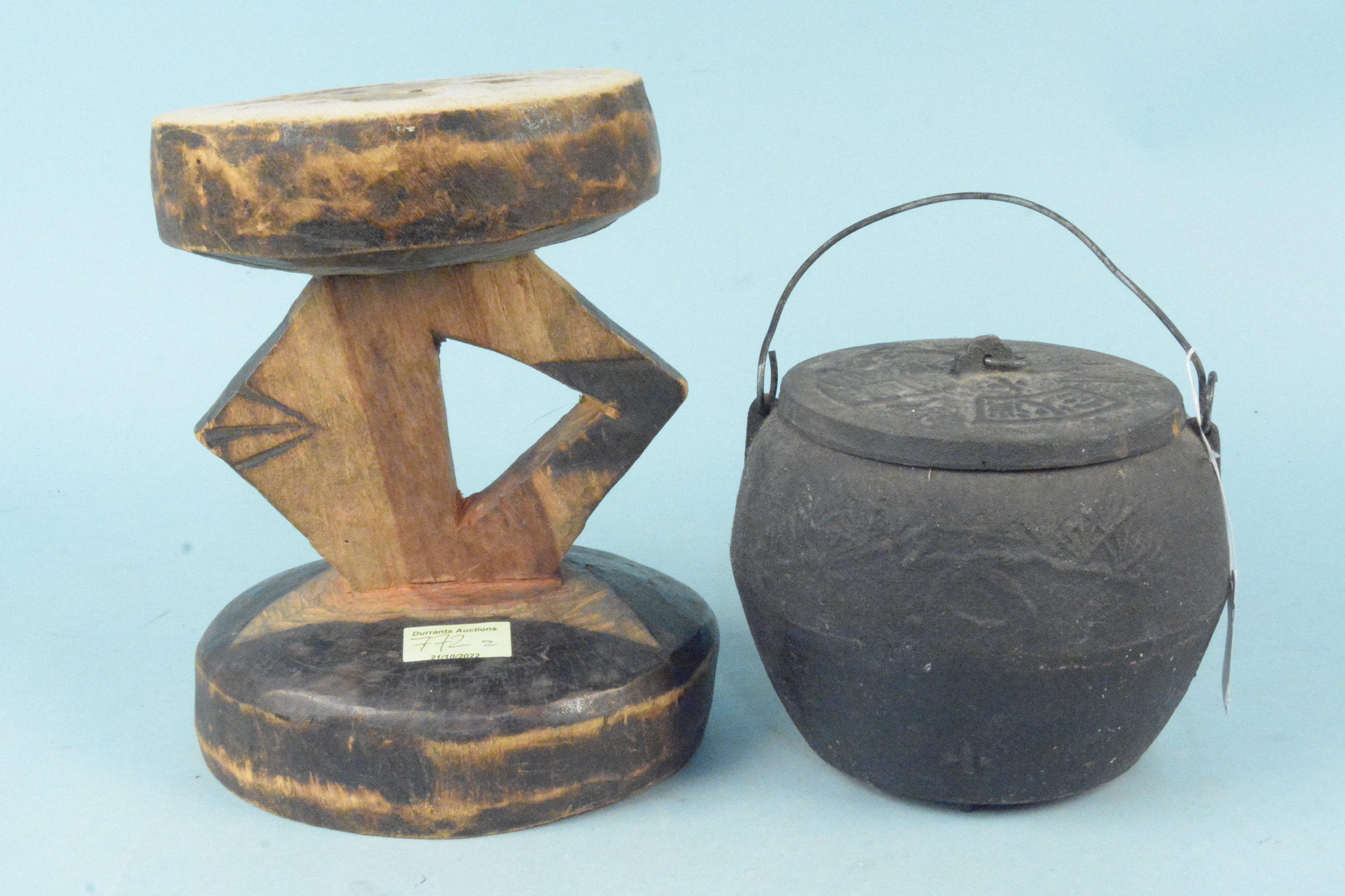 A carved wooden ethnic stool plus an Oriental cast iron cooking pot