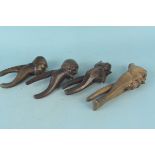 Four vintage continental wooden nut crackers with carved caricature faces and handles