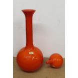 A tall orange glass vase with bulbous base and a tall straight neck with flared rim,
