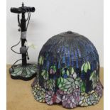 A large Tiffany style table lamp with a large multicoloured stained glass bell shaped shade with