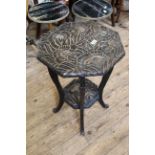 A heavily carved hexagonal top two tier occasional table