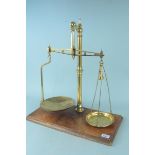 A set of late 19th Century brass shop scales by W & T Avery Ltd standing on substantial mahogany