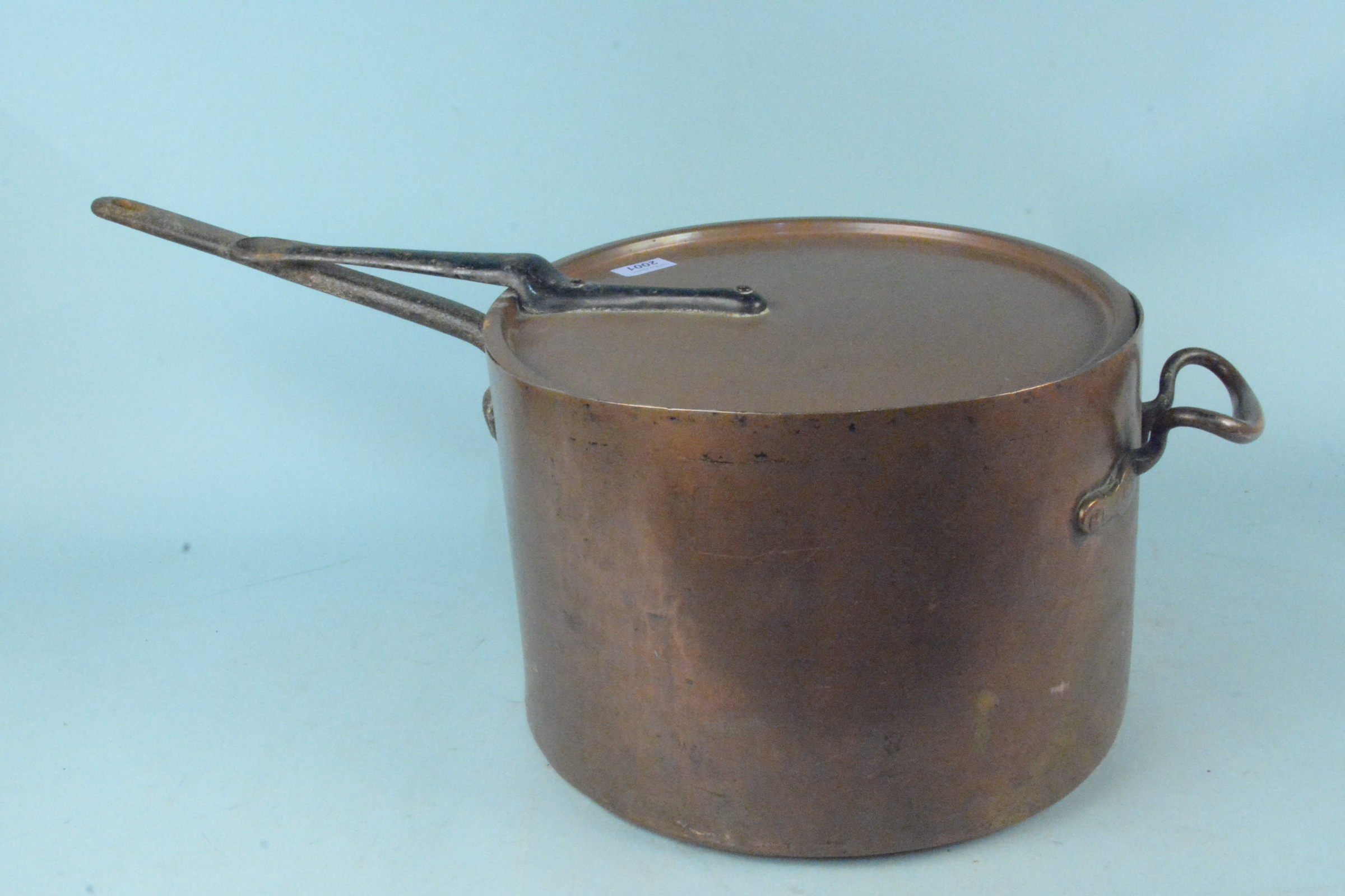 A large heavy 19th Century seamed copper saucepan having copper and iron handles with a lid having