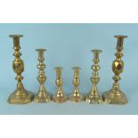 Two pairs of large Victorian brass candlesticks on heavily turned stems plus a smaller pair on oval