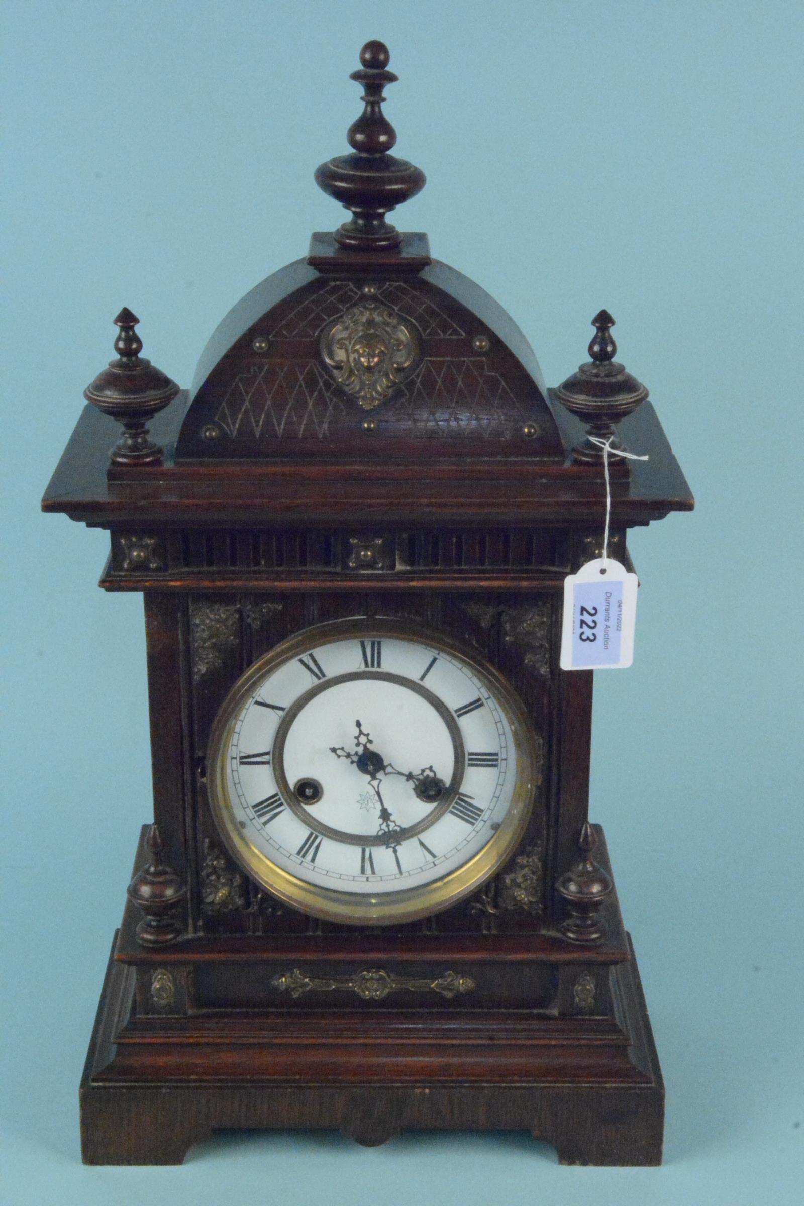 A Junghans German large wooden cased mantel clock with enamel face and brass ornamentation,