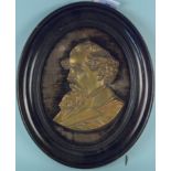A framed brass plaque of a Victorian gentleman,