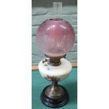 An antique oil lamp with pottery reserve and cranberry to clear glass shade (age related wear)
