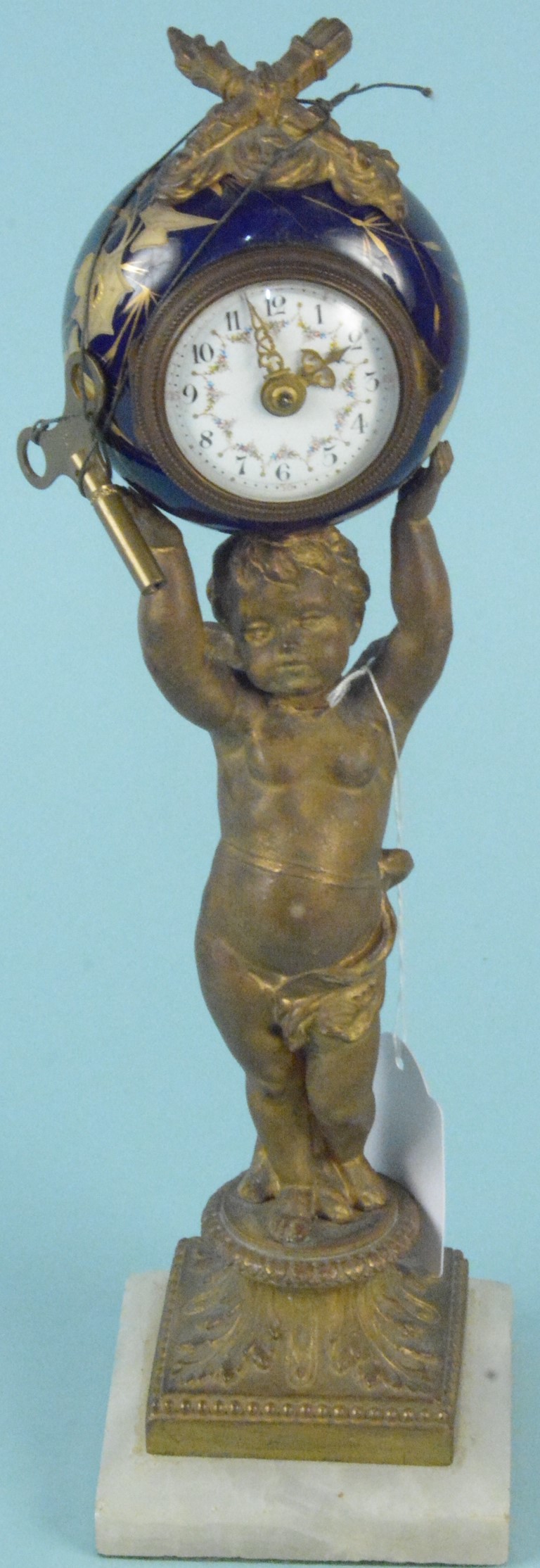 A 19th Century French gilded metal cherub supporting a ceramic clock,