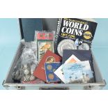 An aluminium case containing commemorative coins and coins sets plus a world coin book