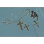 Three 9ct gold cross pendants, two on yellow metal chains,