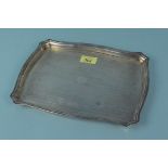 A silver dressing table tray with engine turned decoration and vacant cartouche to centre,