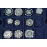 Ten coins in a tray, most appear silver proof,