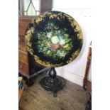 A mid 19th Century ebonised and florally decorated tilt top table