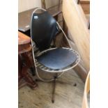 A vintage egg shaped black and chrome office chair