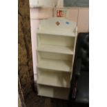 A white painted free standing stepped bookcase of small proportions