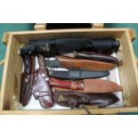 A small wooden crate containing ten various knives with their scabbards
