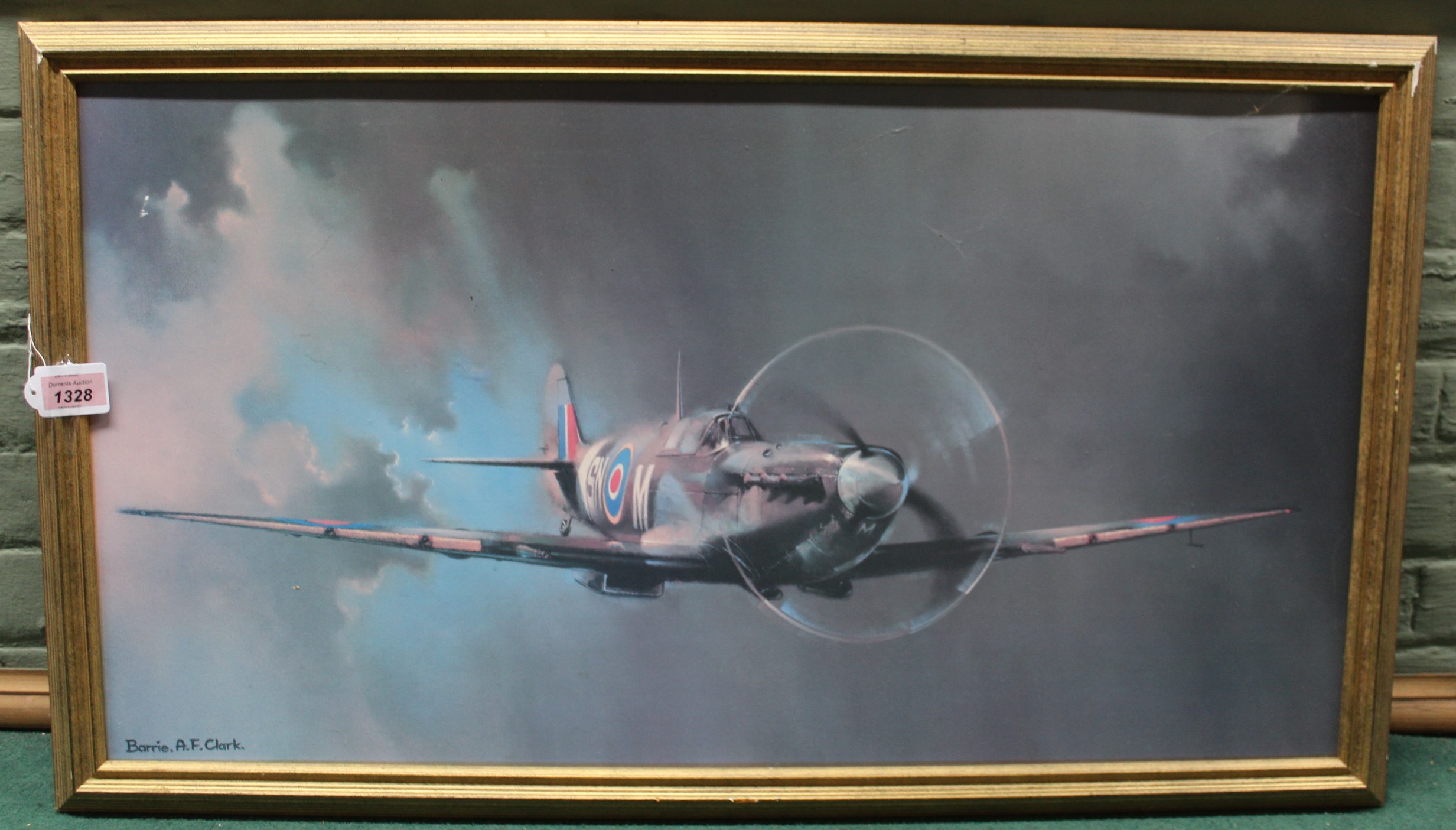 A large framed print of a spitfire in flight by A F Clark, 81.