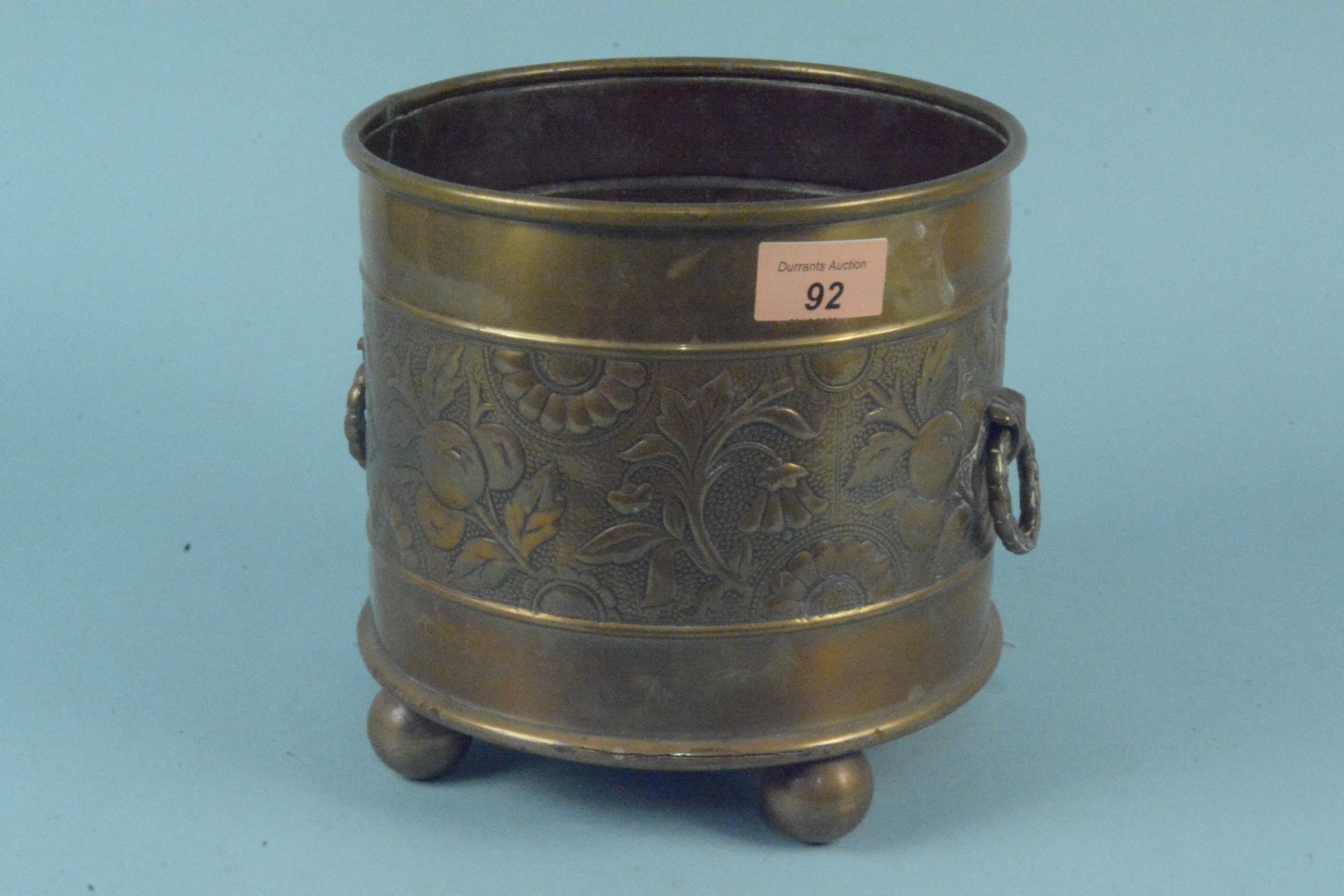 Aesthetic movement circular brass jardiniere with repousse decoration of fruit and flowers,
