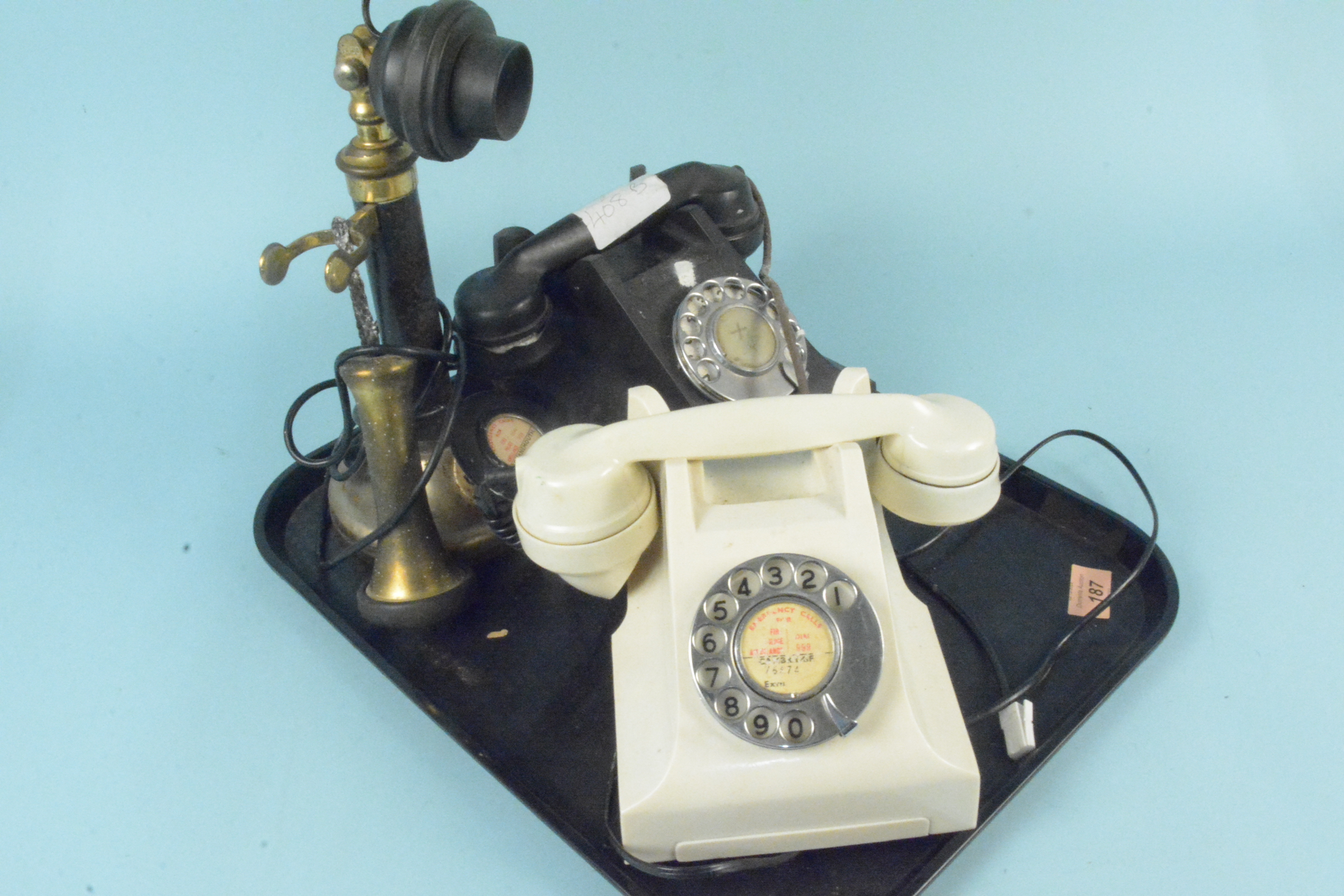 Two vintage Bakelite dial telephones plus a stick phone